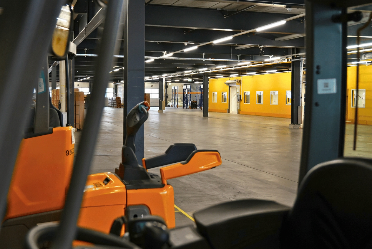 Stapler zwischen Palettenreihen in der Lagerhalle